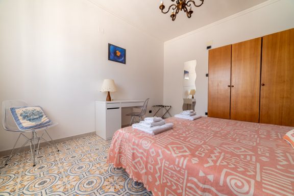 Camera pin on a room with a double bed, wooden cabinets, and minimalist decor.