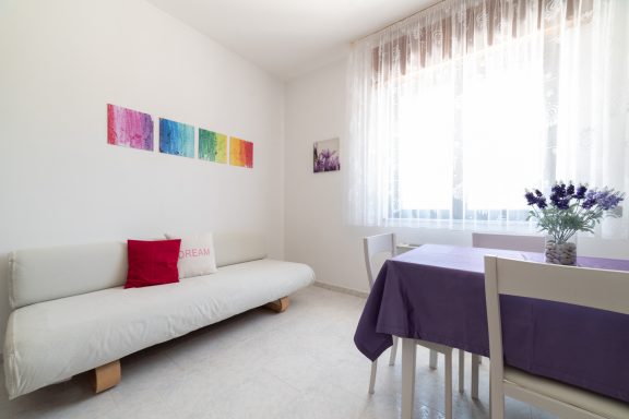 Bright, modern living space with a sofa, table, and decorative wall art.